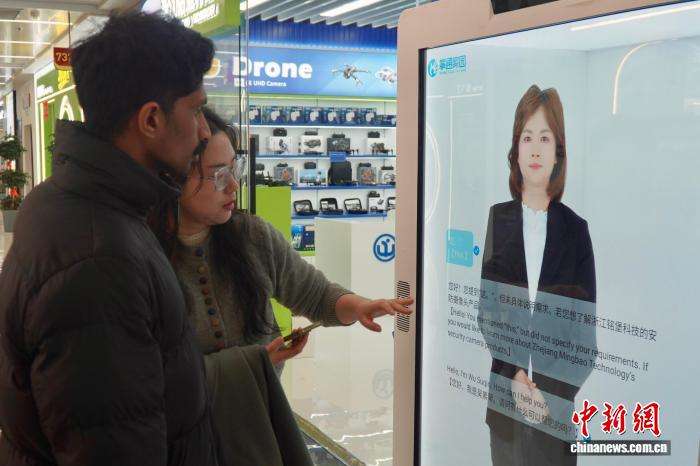 2月28日，浙江义乌，中外客商在店铺门前与多语种数字人对话，了解市场及产品。董易鑫摄